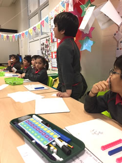 Image of boy standing up in classroom