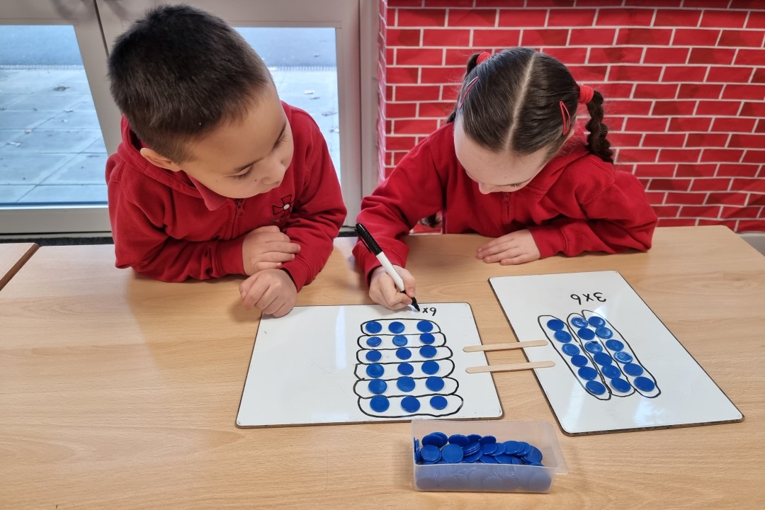 Two Children With Counters Learning About Commutativity
